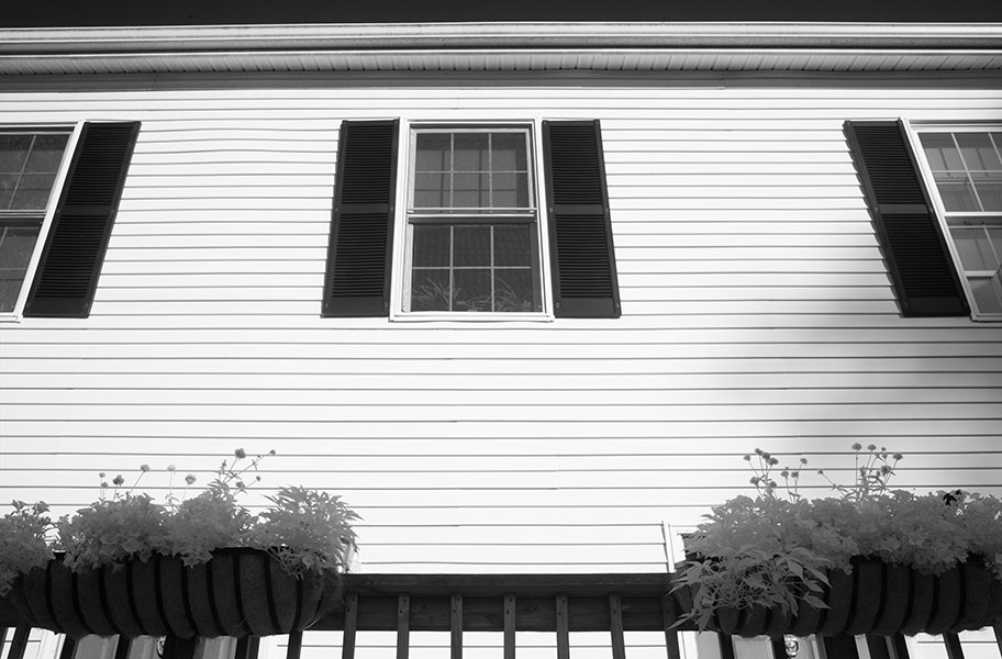 Stark Infrared Photo of Small Apartment Building with Balcony and Plants.